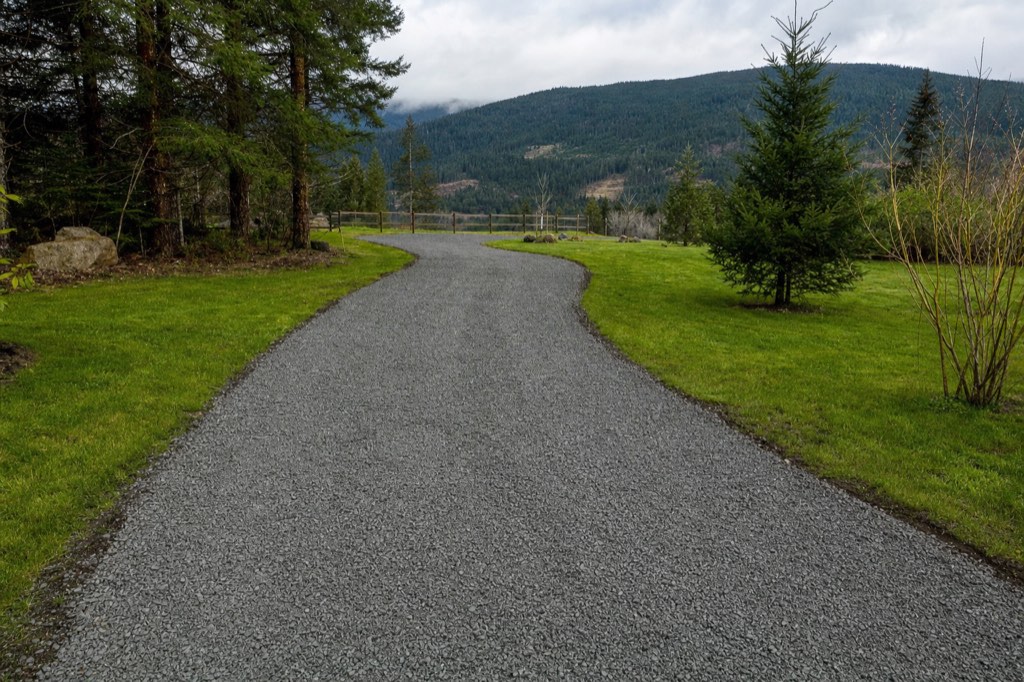 New compacted gravel driveway on a rural Fraser Valley property with trees alongside